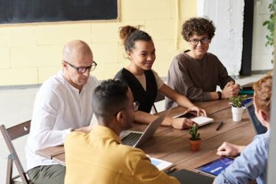 Zdjęcie Ludzi Opartych Na Drewnianym Stole - Fot. fauxels