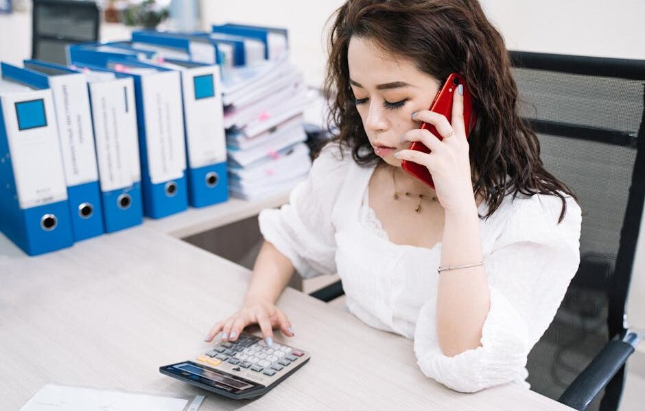 Kobieta W Białej Koszuli Trzymając Czerwony Smartfon - Fot. Anna Tarazevich