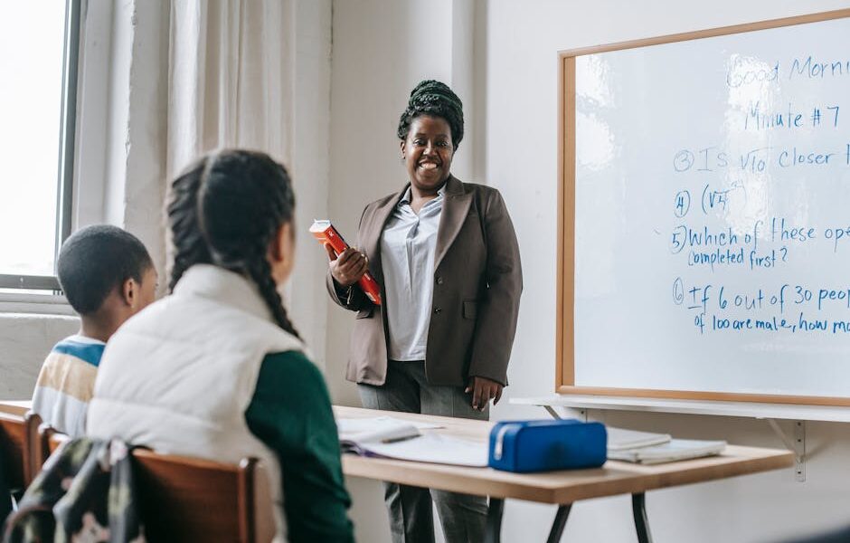 Anonimowi Koledzy Z Klasy Siedzą Przy Stole Podczas Lekcji Matematyki Z Czarną Nauczycielką - Fot. Katerina Holmes