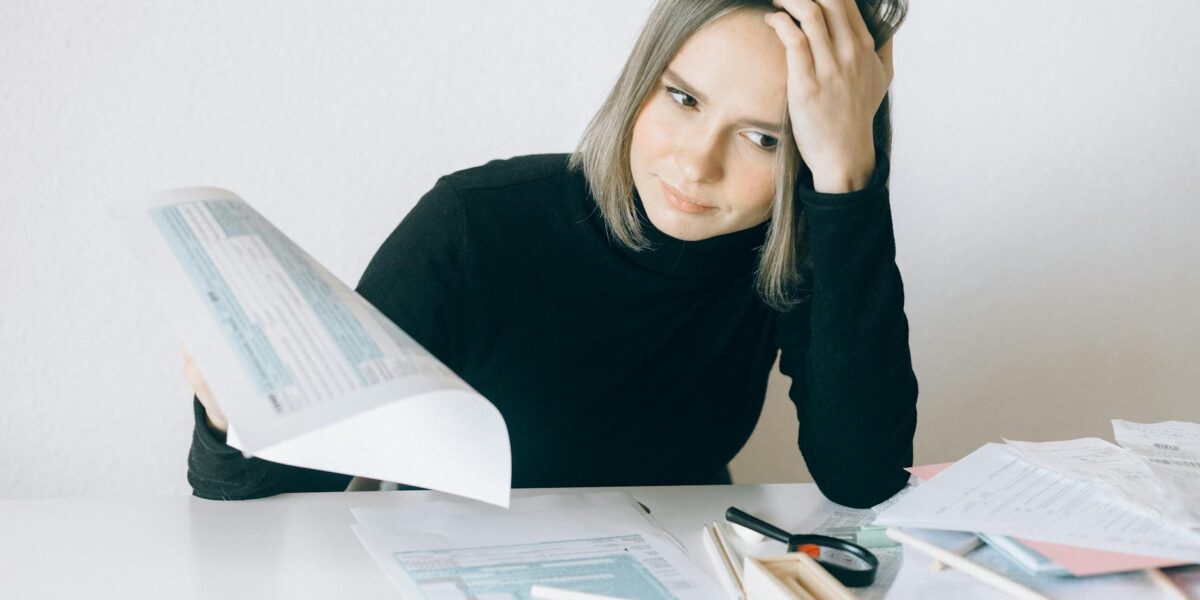 Kobieta analizujaca dokumenty finansowe przy biurku - upadlosc konsumencka poradnik