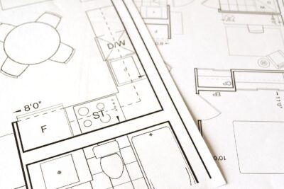 Rzut architektoniczny budynku z wymiarami rozłożony na stole