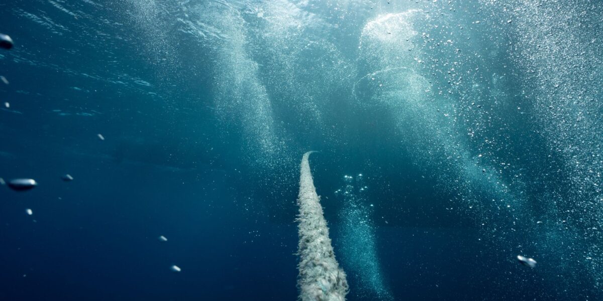 Explore the deep blue underwater world with bubbles, rope, and ambient light., zdjęcie ilustracyjne